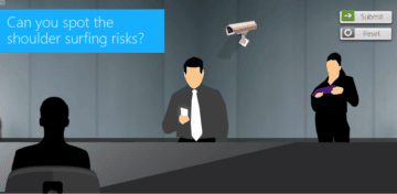 Man sitting at a table with a security camera mounted on the wall behind him and a woman standing behind him on the left.